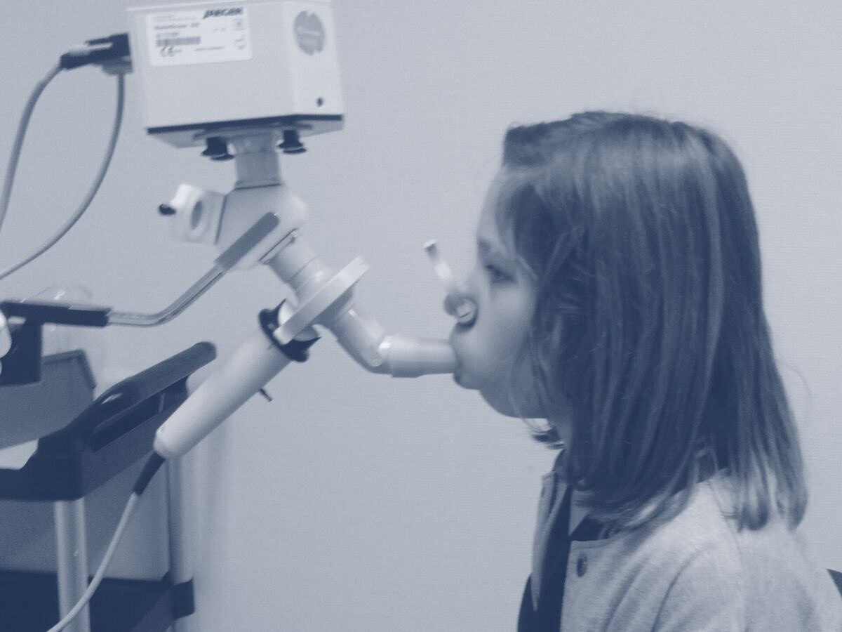 A patient blowing into a spirometer mouthpiece
